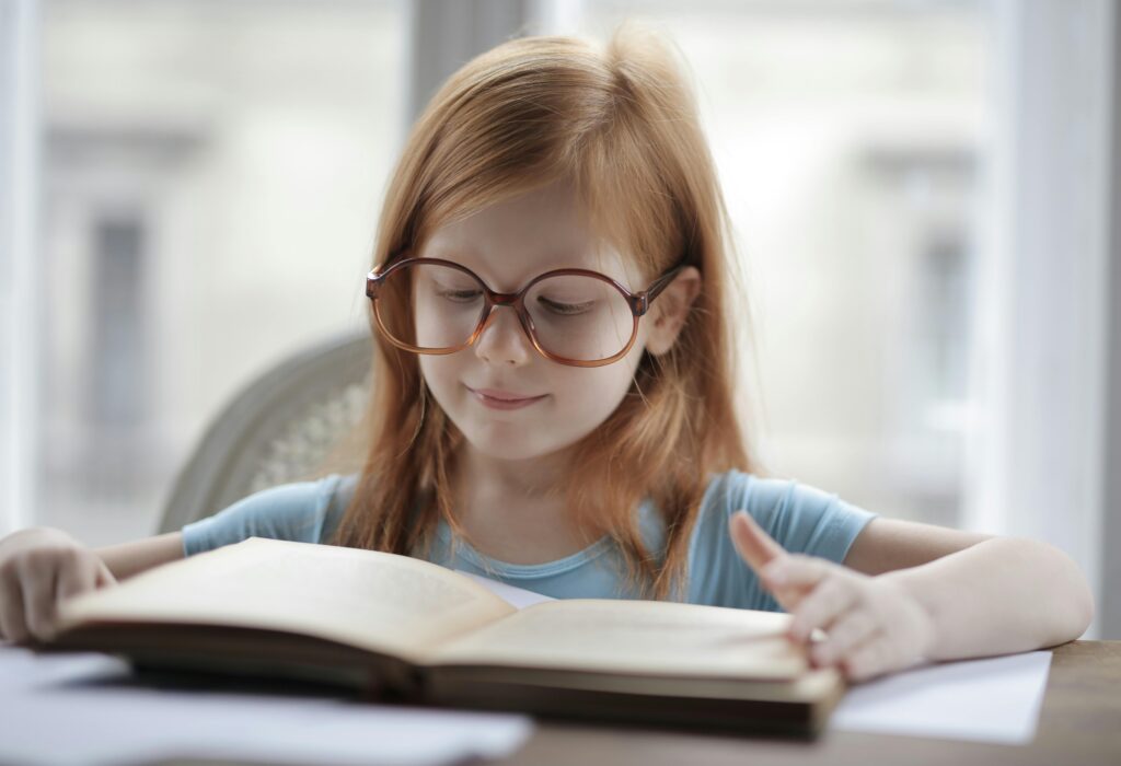 Child reading at desk showing near work associated with early myopia